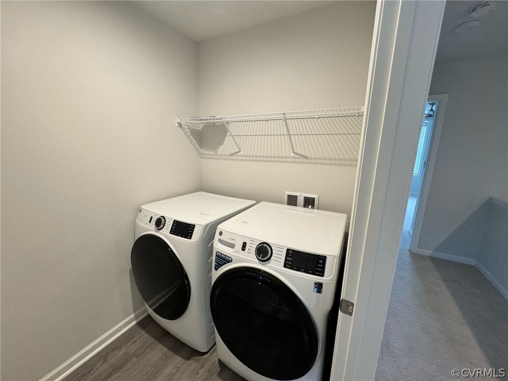 Laundry area with hookup for a washing machine, dark hardwood / wood-style floors, and washer and dryer