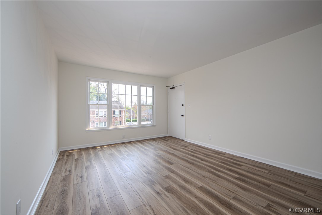 The spacious family room  boasts LVP flooring, fresh paint and lots of light.