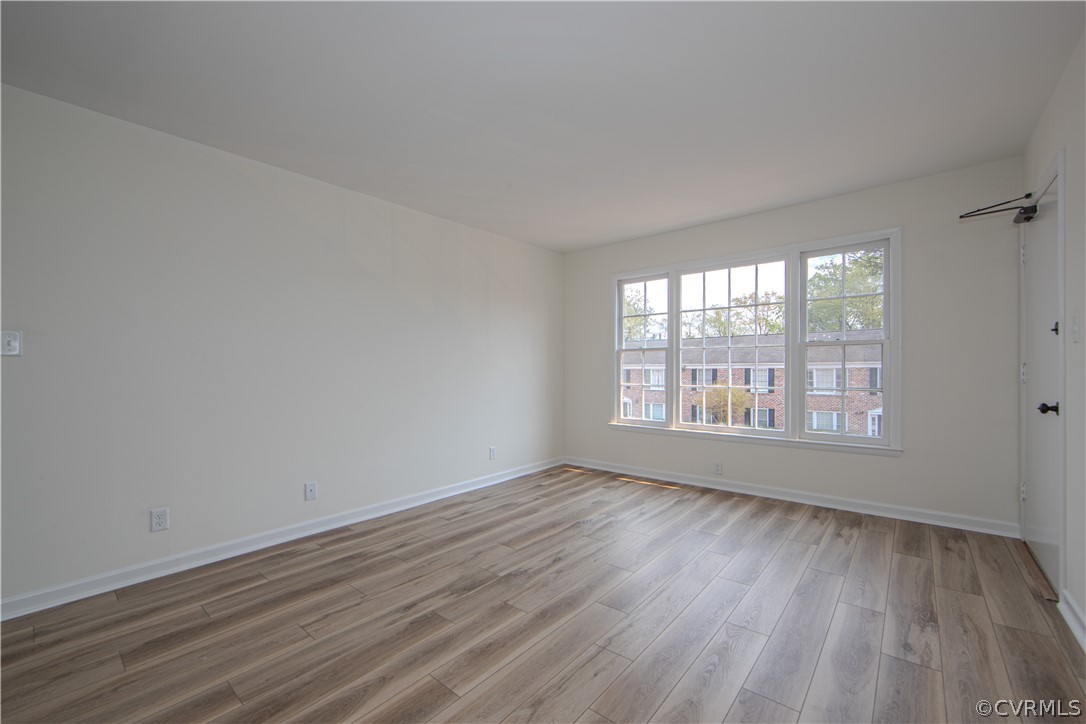 Additional view of the spacious family room with durable new LVP flooring, fresh paint and lots of light.