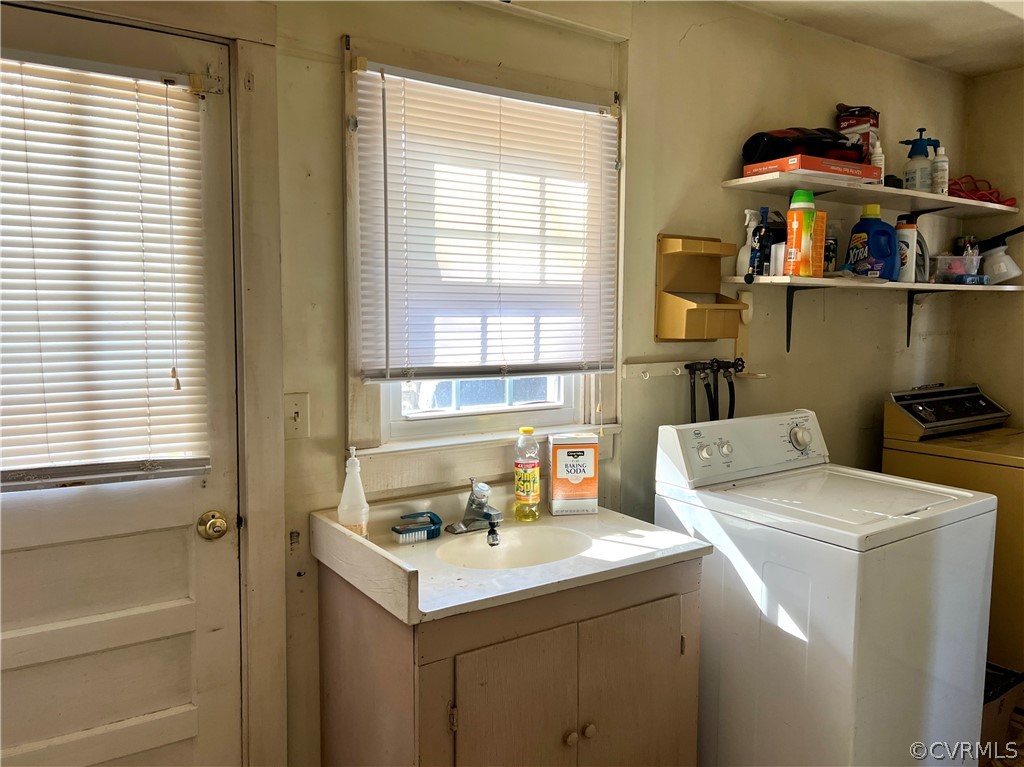 Laundry area with sink, washer hookup, and washing machine and clothes dryer