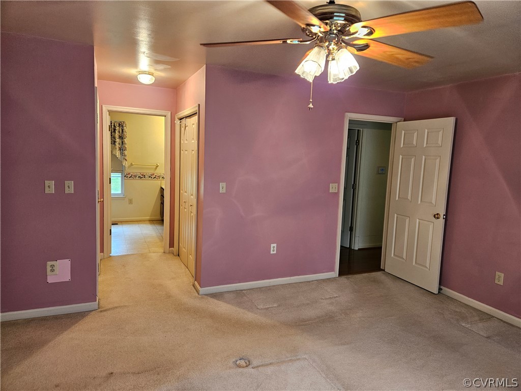 Unfurnished bedroom with a closet, ceiling fan, and light carpet