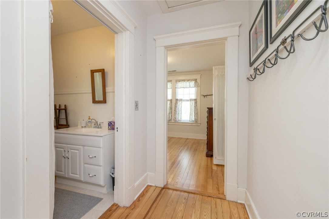 Hallway featuring sink and light hardwood / wood-style floors