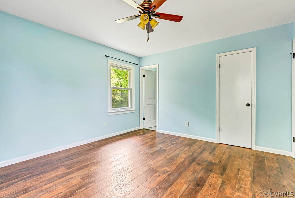 Primary Bedroom with hardwood / wood-style floors and ceiling fan