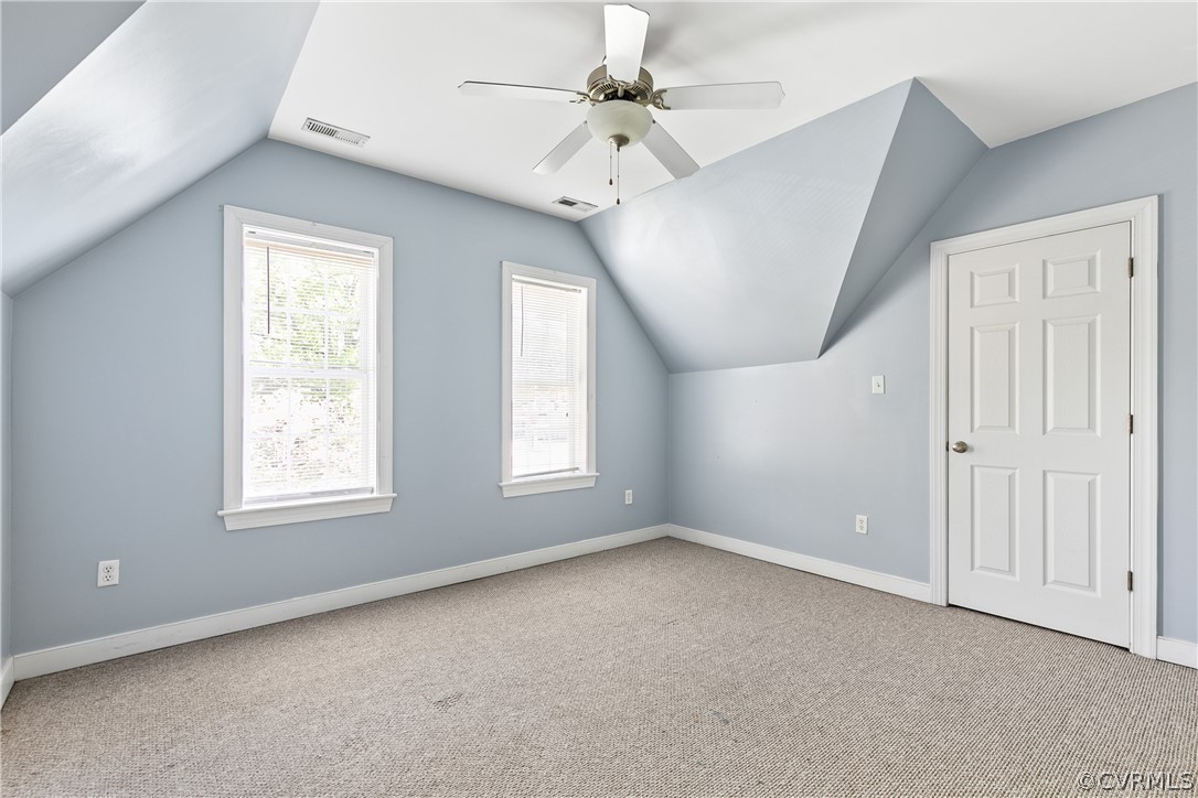 Bonus room featuring ceiling fan, vaulted ceiling, and light carpet