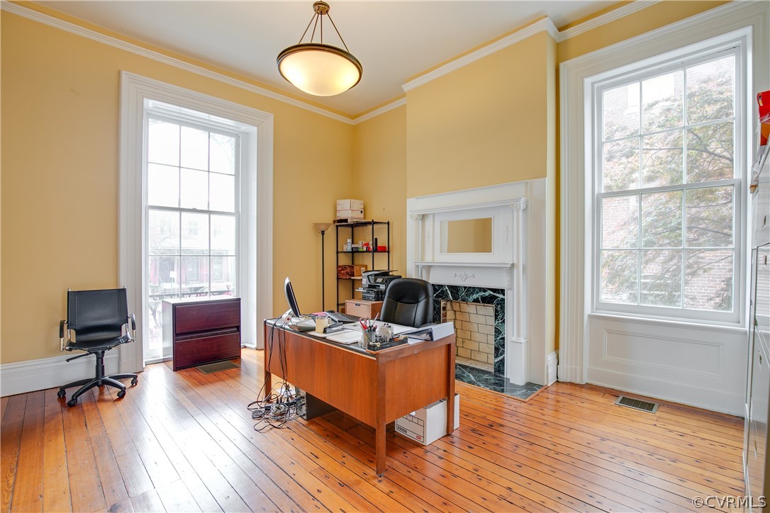 Office area featuring a wealth of natural light, a high end fireplace, and hardwood / wood-style floors