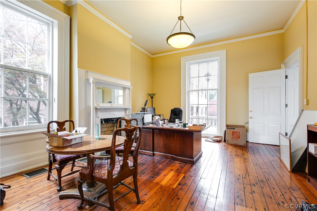 Office area with hardwood / wood-style floors and crown molding
