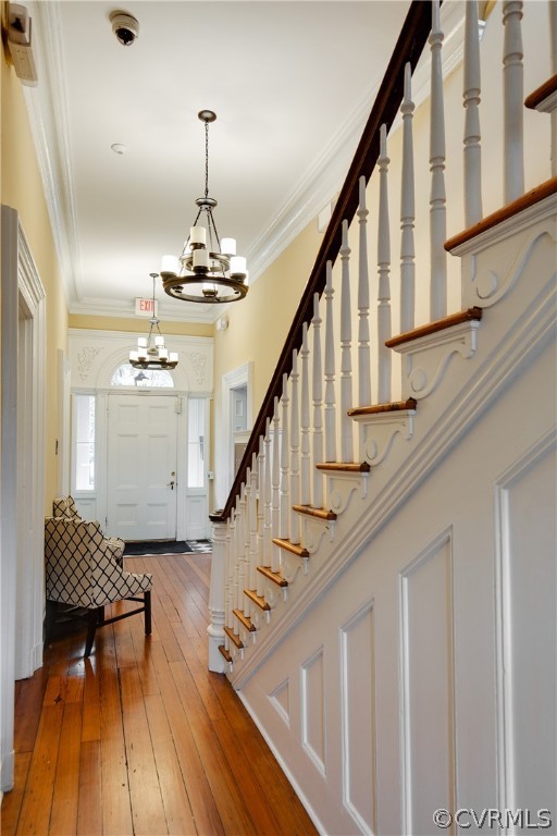 Entryway featuring a notable chandelier, crown molding, and hardwood / wood-style flooring