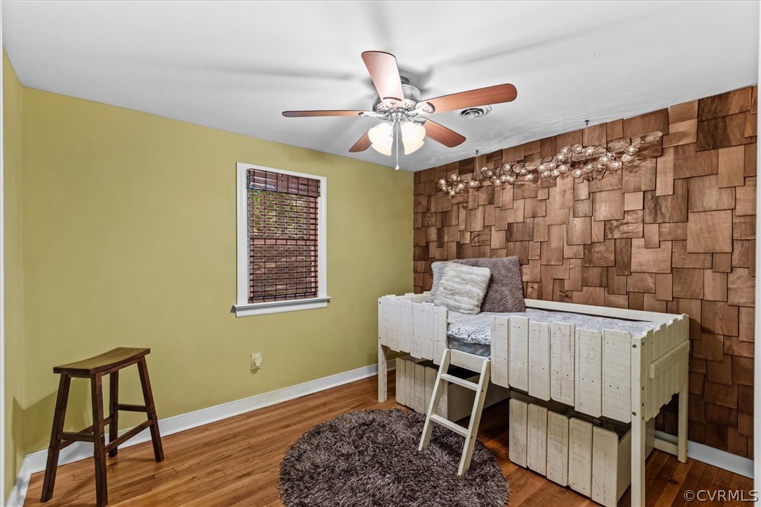 Bedroom featuring hardwood / wood-style floors, multiple windows, and ceiling fan