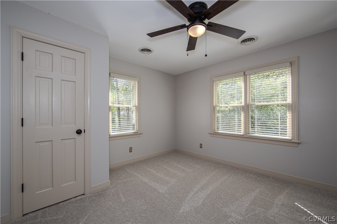 Sitting room with ceiling fan features 2 closets!