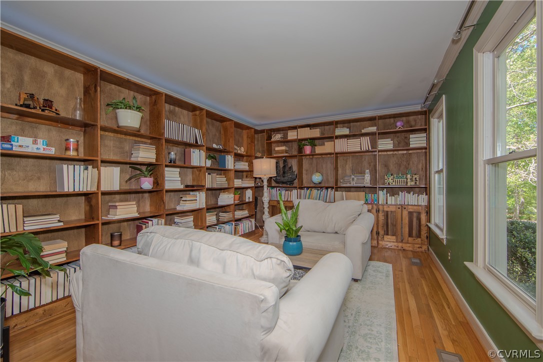 Living room with hardwood flooring and built in book shelves!