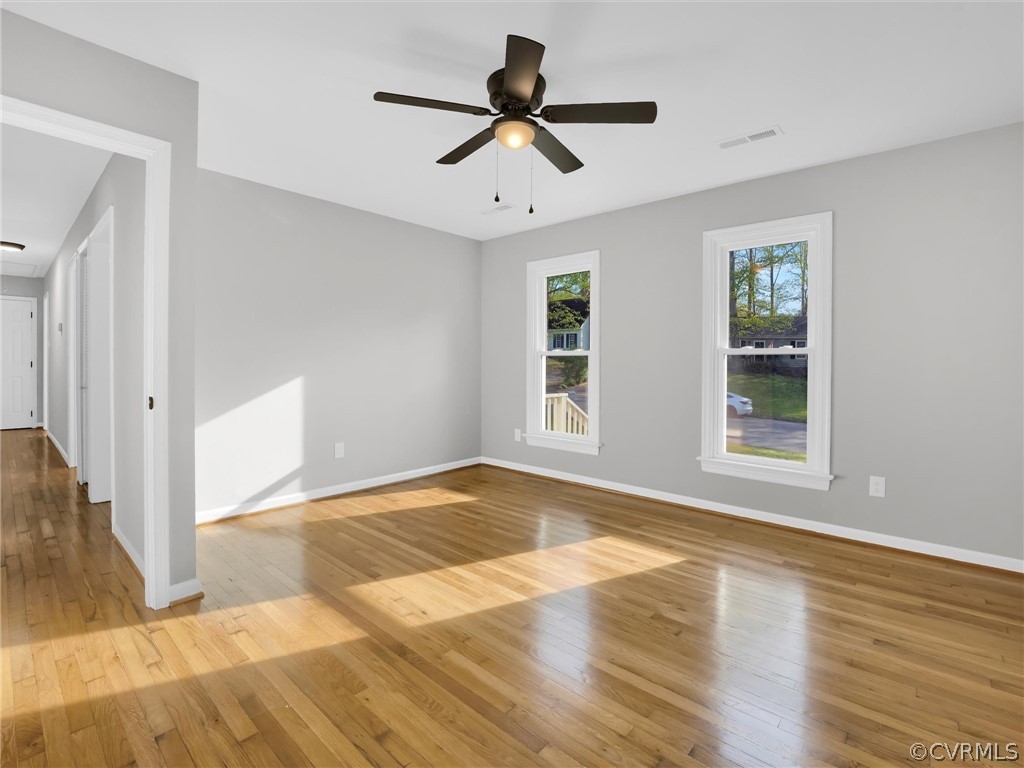 Empty room with ceiling fan and light wood-type flooring