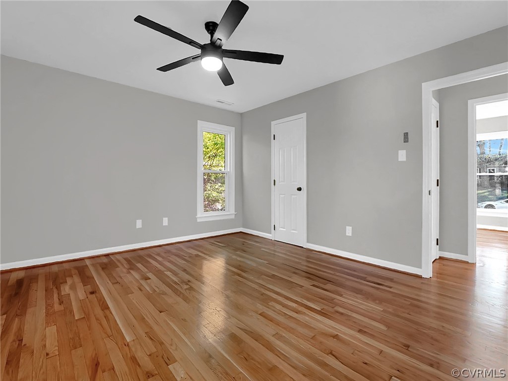 Empty room with wood-type flooring and ceiling fan