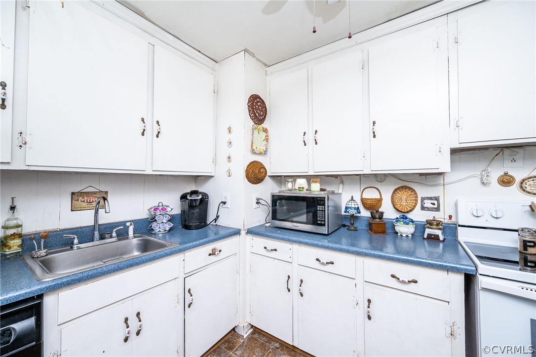 Kitchen with sink, white electric range oven, backsplash, white cabinetry, and black dishwasher