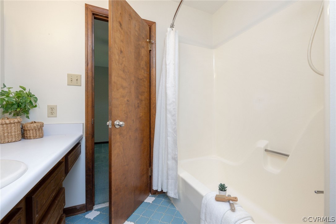 Bathroom featuring tile flooring, vanity, and shower / tub combo with curtain