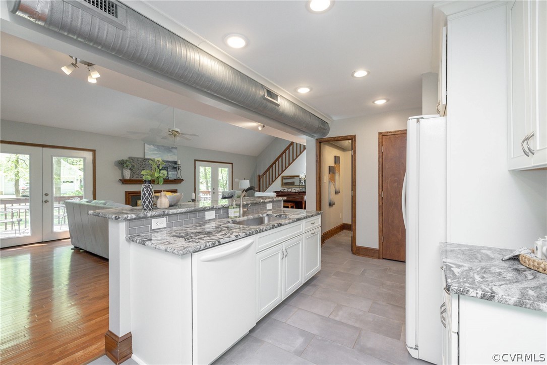 Kitchen featuring plenty of natural light, white cabinets, and light tile floors