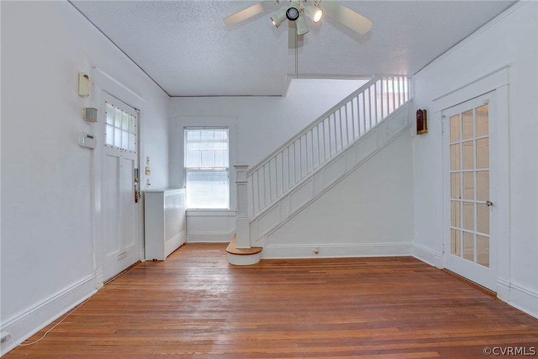 Foyer featuring ceiling fan, hardwood / wood-style flooring, and a textured ceiling