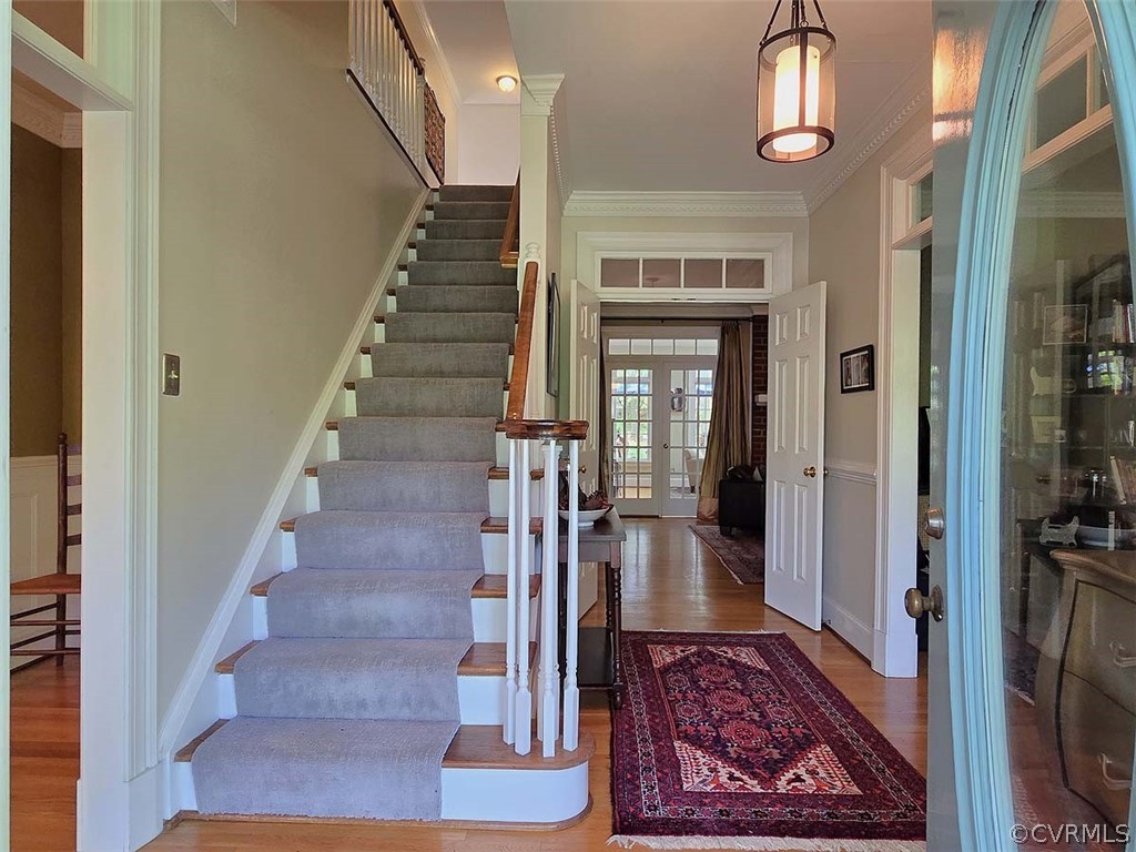 Foyer featuring french doors, ornamental molding, and wood-type flooring