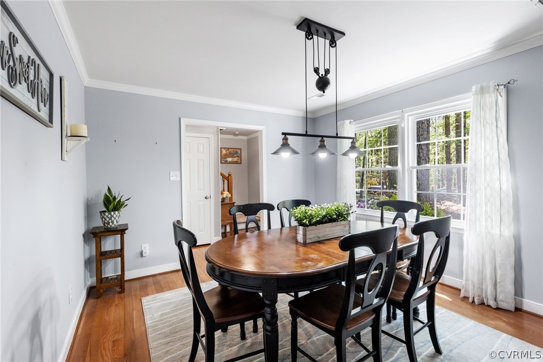 Dining room featuring hardwood / wood-style floors and crown molding