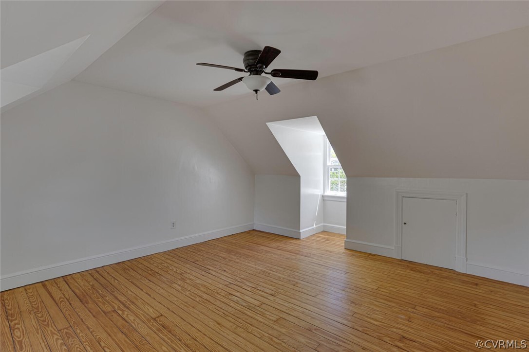 Additional living space featuring ceiling fan, vaulted ceiling, and light wood-type flooring