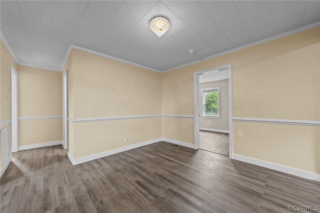 Spare room featuring ornamental molding and dark hardwood / wood-style floors