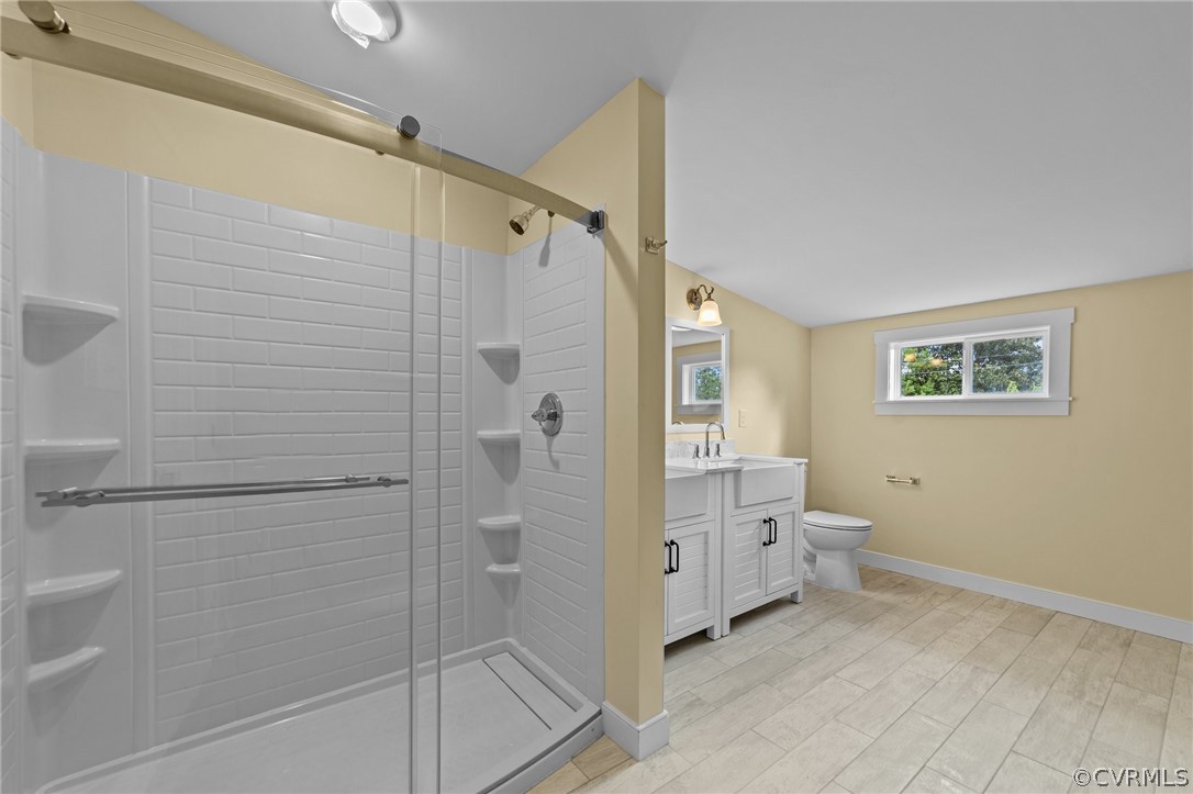 Bathroom featuring walk in shower, wood-type flooring, vanity, and toilet
