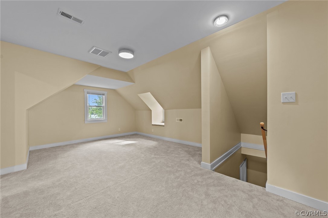 Additional living space featuring lofted ceiling and carpet floors
