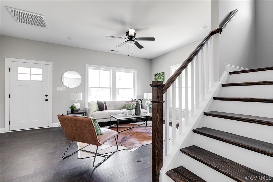 Stairway featuring plenty of natural light, dark wood-type flooring, and ceiling fan