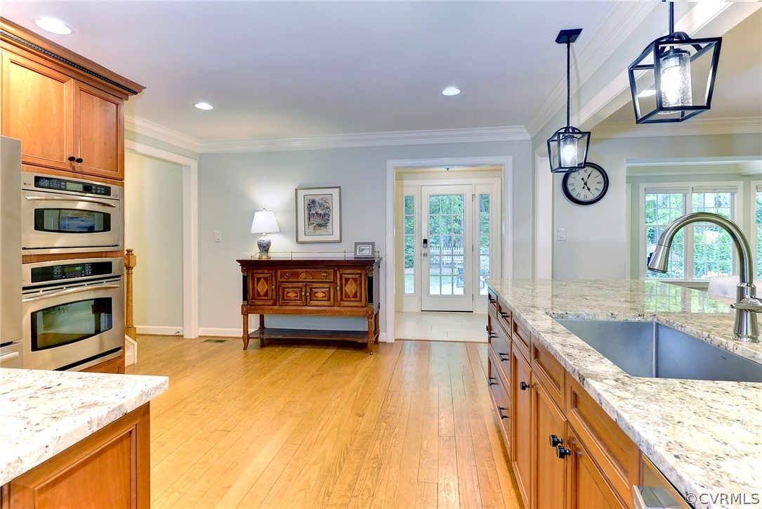 Kitchen featuring a healthy amount of sunlight, pendant lighting, light hardwood / wood-style floors, and sink