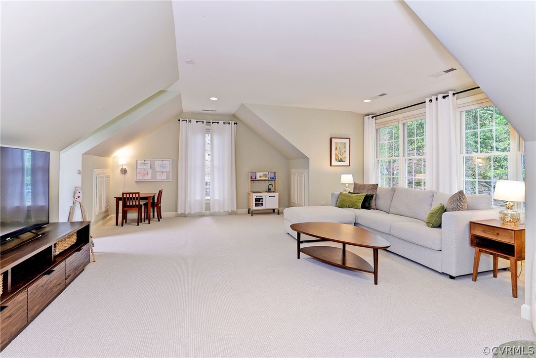 Living room featuring vaulted ceiling and carpet flooring