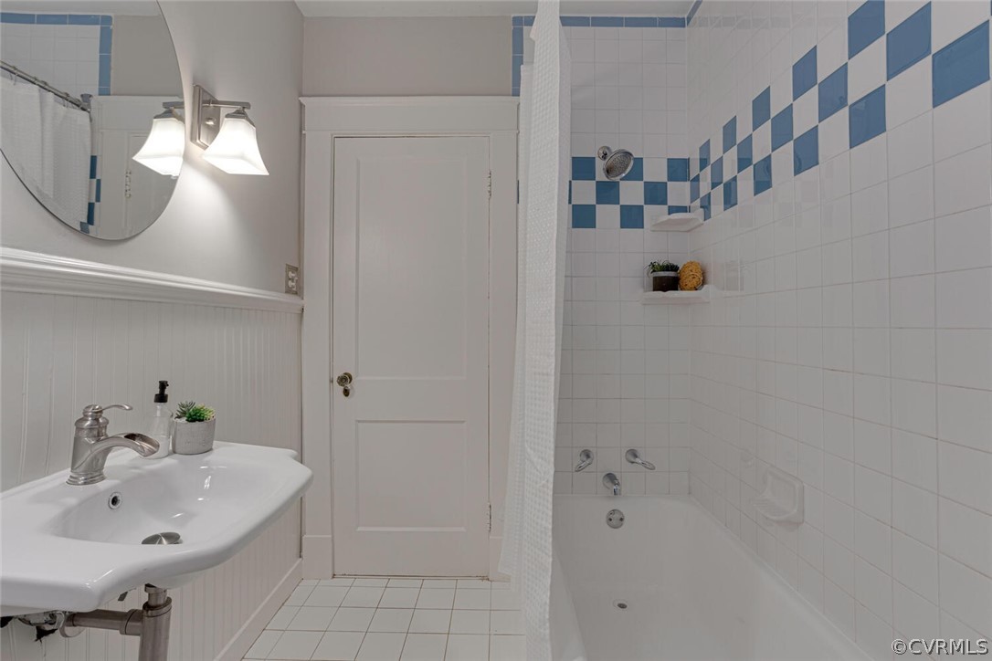 Bathroom with sink, tile floors, and shower / tub combo with curtain