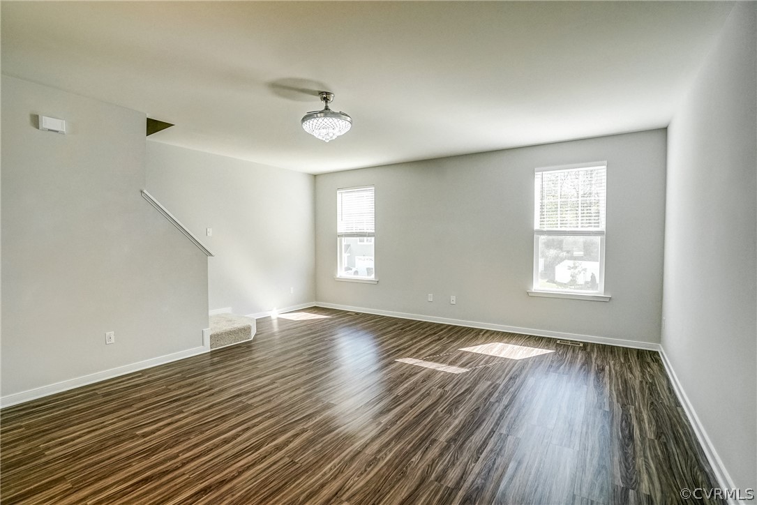 Empty room with dark hardwood / wood-style floors