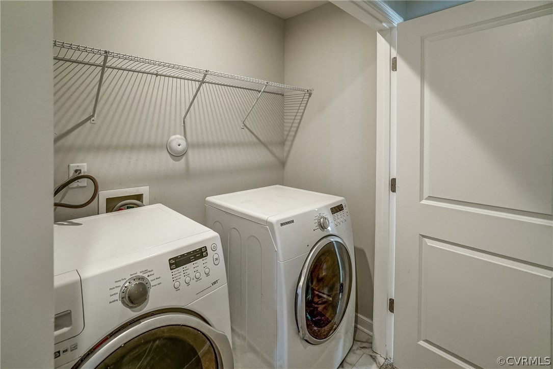 Laundry area with light tile floors, hookup for a washing machine, and washer and clothes dryer