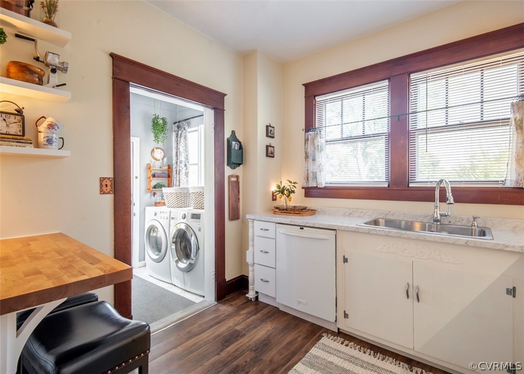 Laundry room with sink, dark wood-type flooring, and washer and clothes dryer
