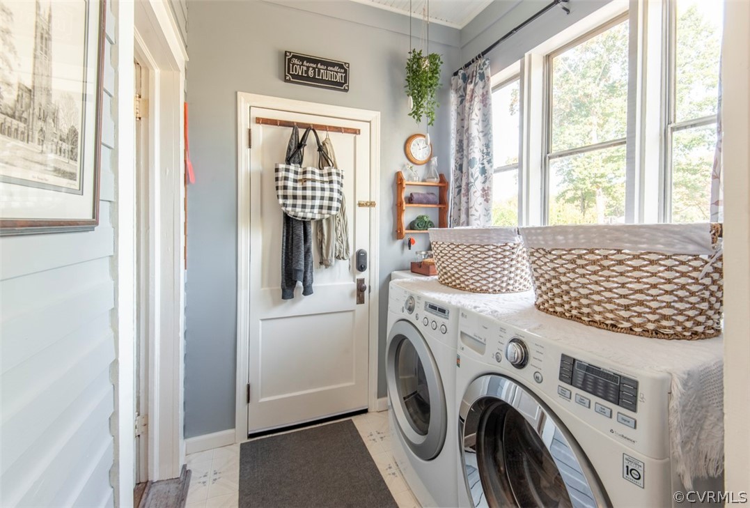 Laundry area featuring washing machine and dryer and light tile flooring