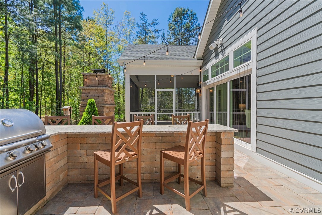 Outdoor kitchen with granite countertops and built in grill.