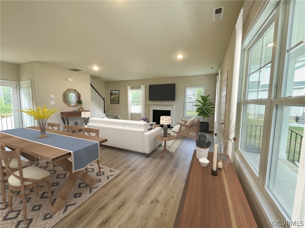 Living room with plenty of natural light and light hardwood / wood-style flooring