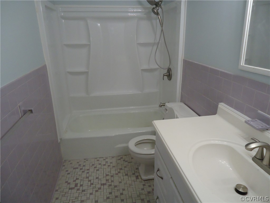 Full bathroom featuring tile flooring, tile walls, tasteful backsplash, shower / tub combination, and toilet