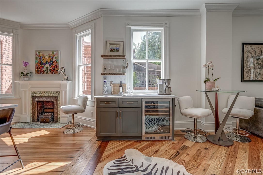 Sitting room featuring ornamental molding, wine cooler, and light hardwood / wood-style floors