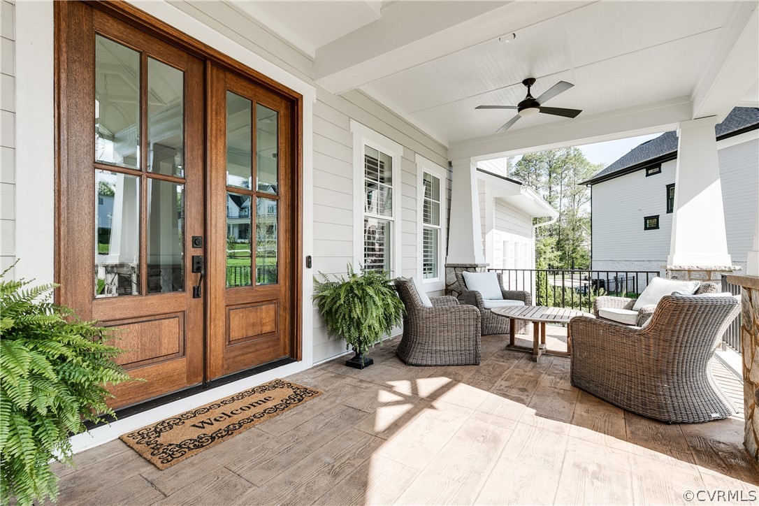 The full front concrete porch provides various seating options, while the double wood door welcomes you home.