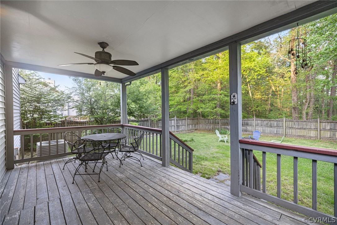Deck featuring ceiling fan and a yard