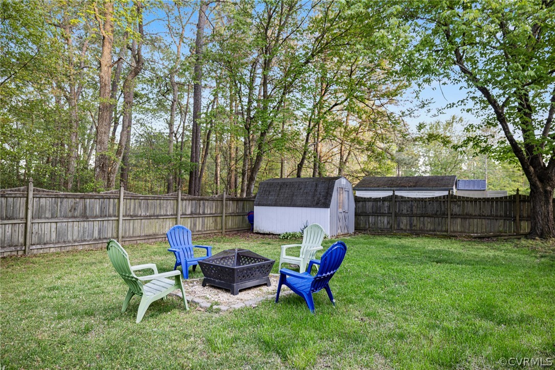 View of yard featuring a fire pit and a storage unit