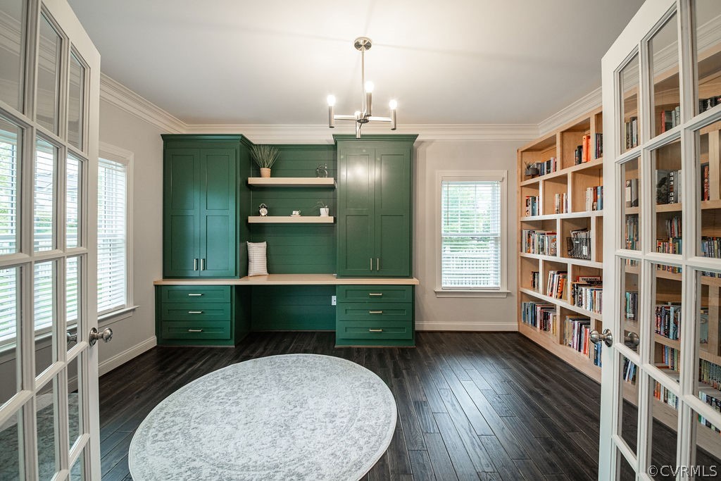 Office featuring crown molding, a notable chandelier, built in desk, and hardwood flooring