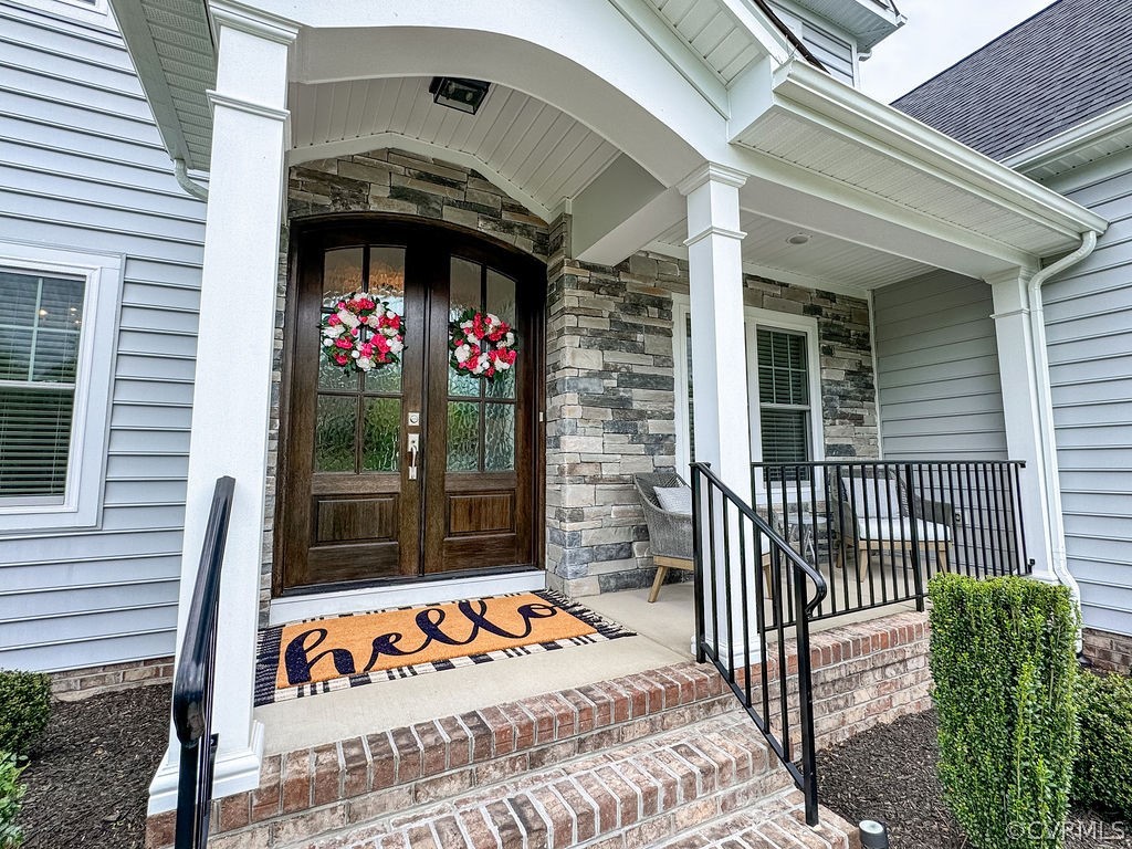 Entrance to property featuring a porch and double front doors.