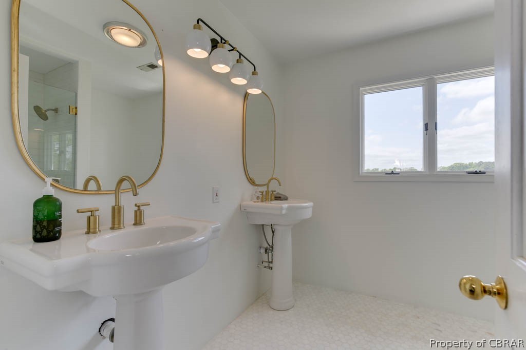 Renovated primary bath with marble floors and views of the water