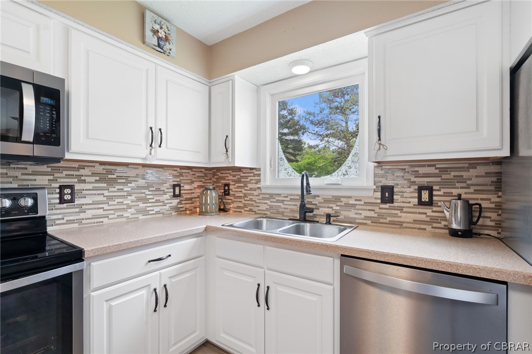 Kitchen has double stainless-steel sink with view of backyard.