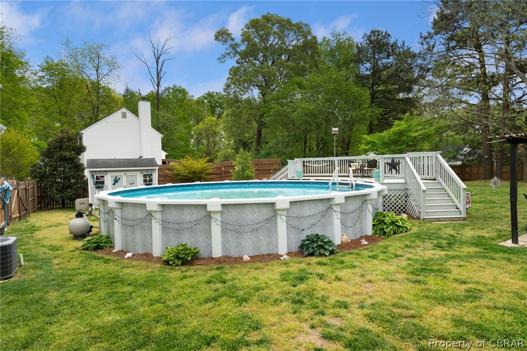 Above ground 30 ft swimming pool in backyard. Picture shows storage shed in background.