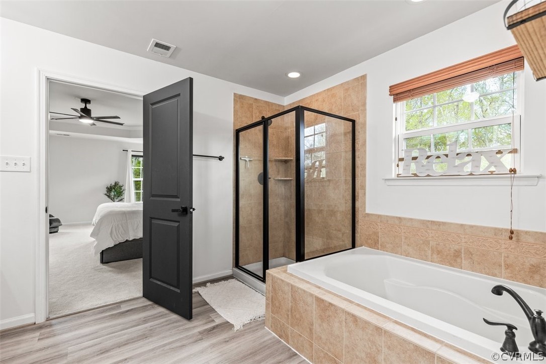 Bathroom with independent shower and bath, ceiling fan, and hardwood / wood-style floors