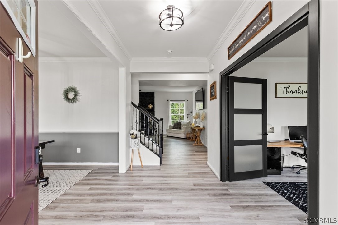 Foyer with crown molding and wood-type flooring