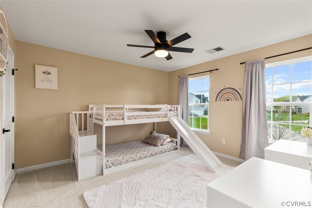Bedroom with multiple windows, carpet flooring, and ceiling fan