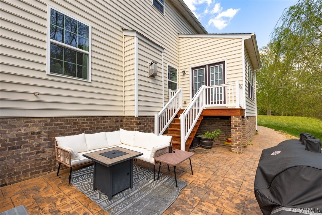 View of patio / terrace featuring grilling area and an outdoor living space with a fire pit